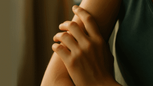 Hand gently resting on forearm – a silent metaphor for healing.